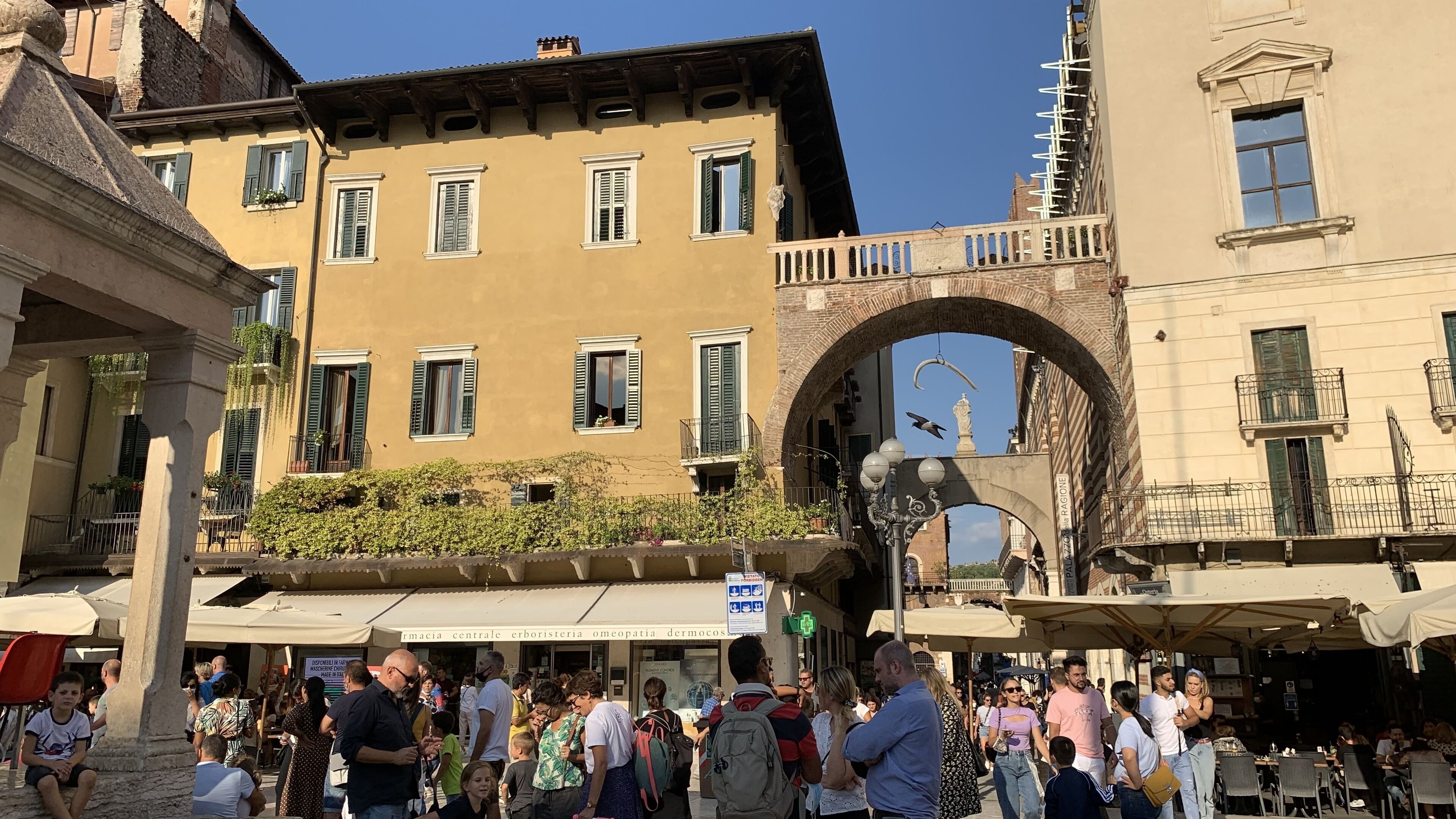 A busy outdoor market area with people and shops.
