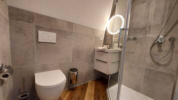 Un baño moderno con inodoro, lavabo y ducha.