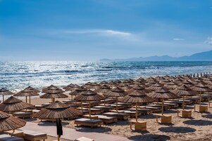 Praia particular, espreguiçadeiras, guarda-sóis, toalhas de praia 
