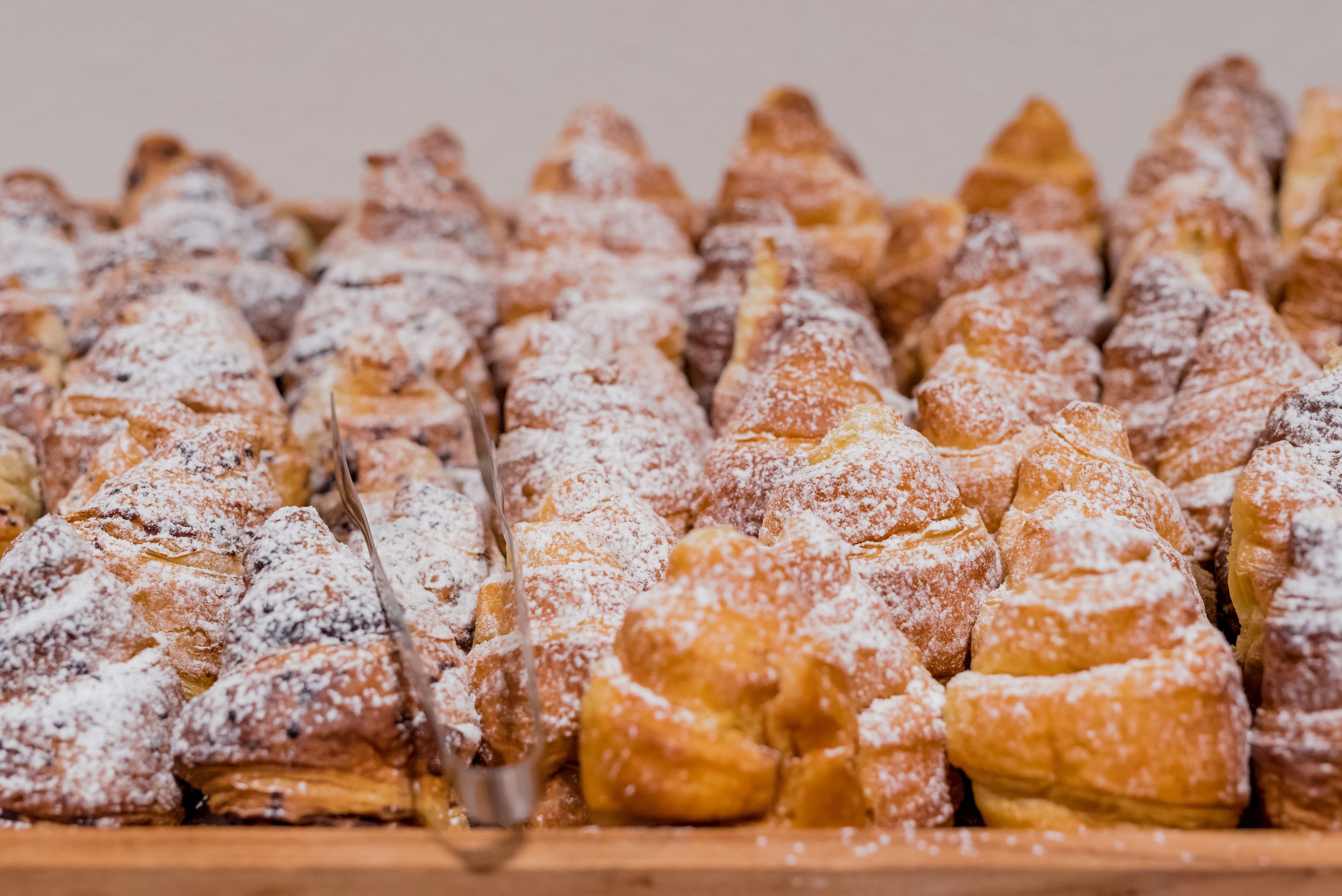 A tray of pastries dusted with powdered sugar.