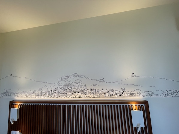 A wall with a black and white cityscape mural.