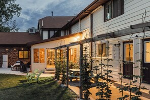 Uma casa com varanda coberta, área de estar externa e fachada de tijolos.