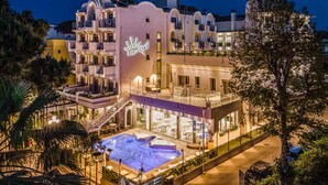 Un hôtel doté d’une piscine, d’un espace extérieur aménagé et d’une façade au style architectural particulier.