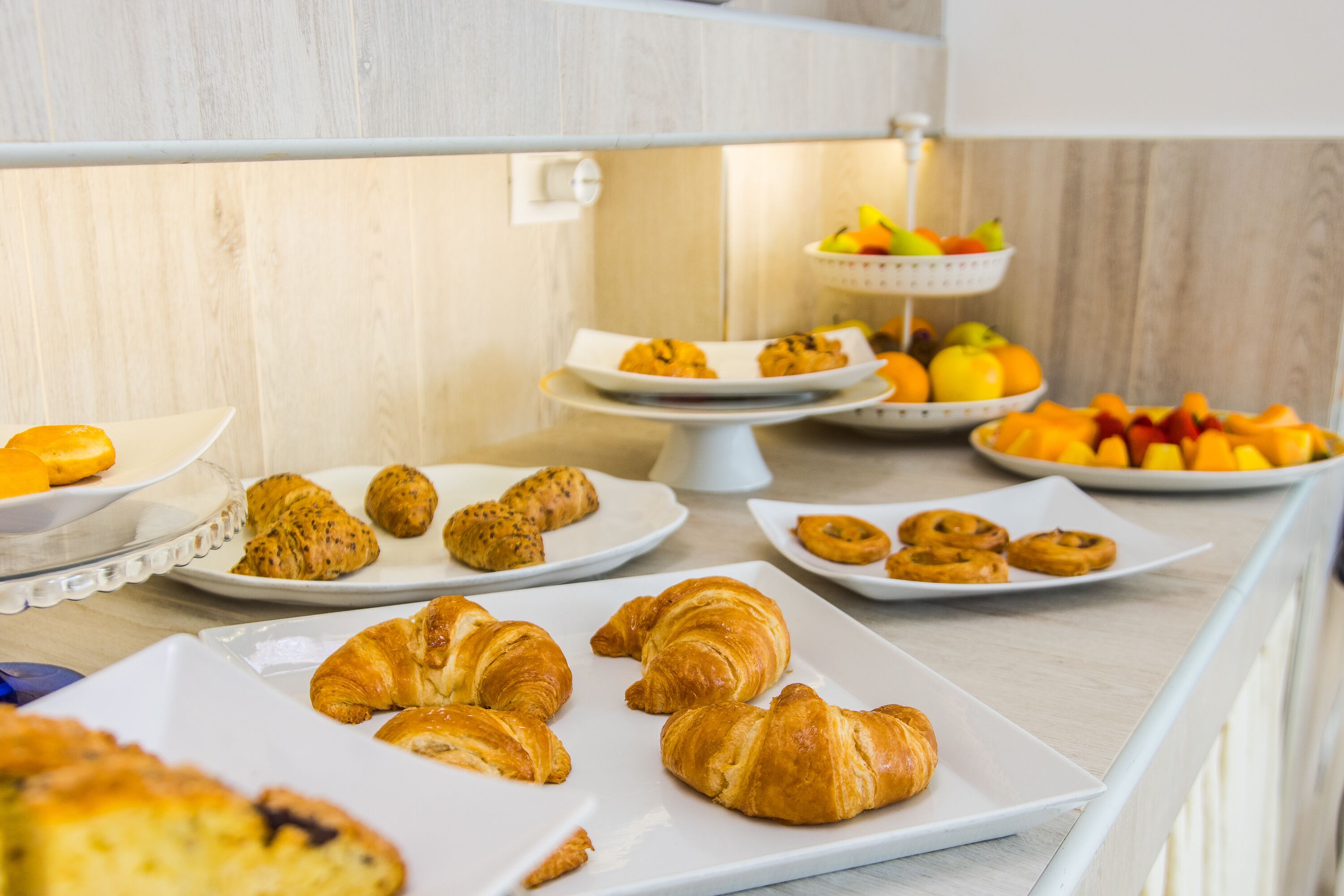 A breakfast buffet with various pastries and fruits.