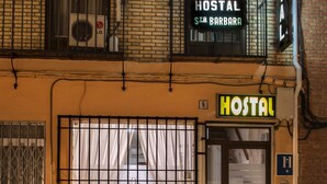 A building with a sign reading "HOSTAL STA. BARBARA" and a neon sign above the entrance. - Hostal Santa Bárbara (Toledo)