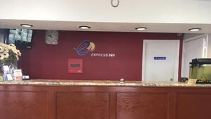 A reception desk with a clock, a digital display, and a sign for Express Inn. - Express Inn West Memphis (West Memphis)