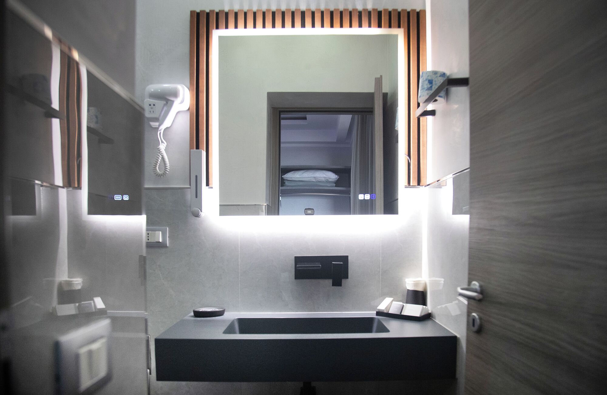 Un baño moderno con un espejo grande, un lavabo y un perchero para toallas.