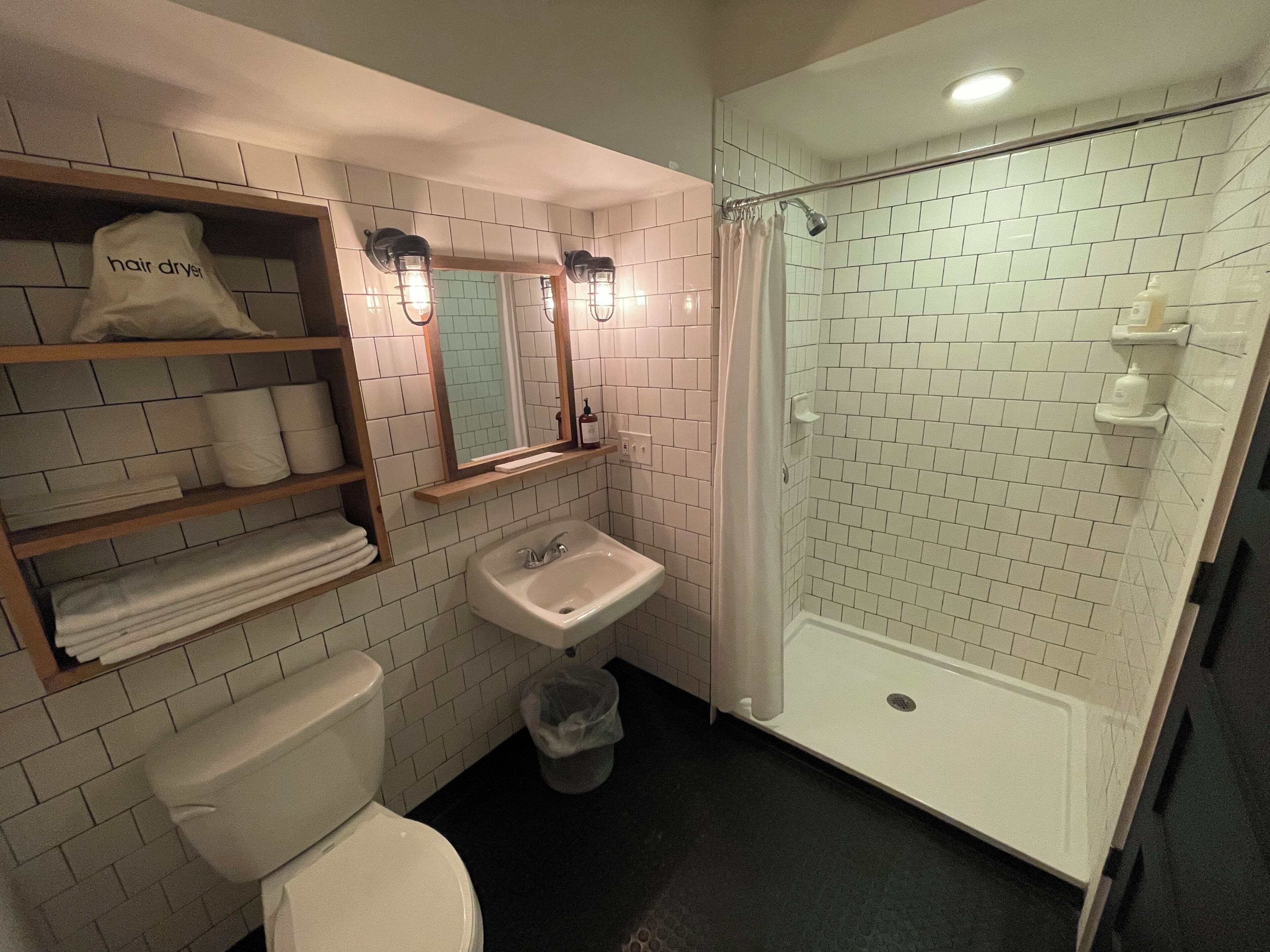 A bathroom with a toilet, sink, and glass-enclosed shower.