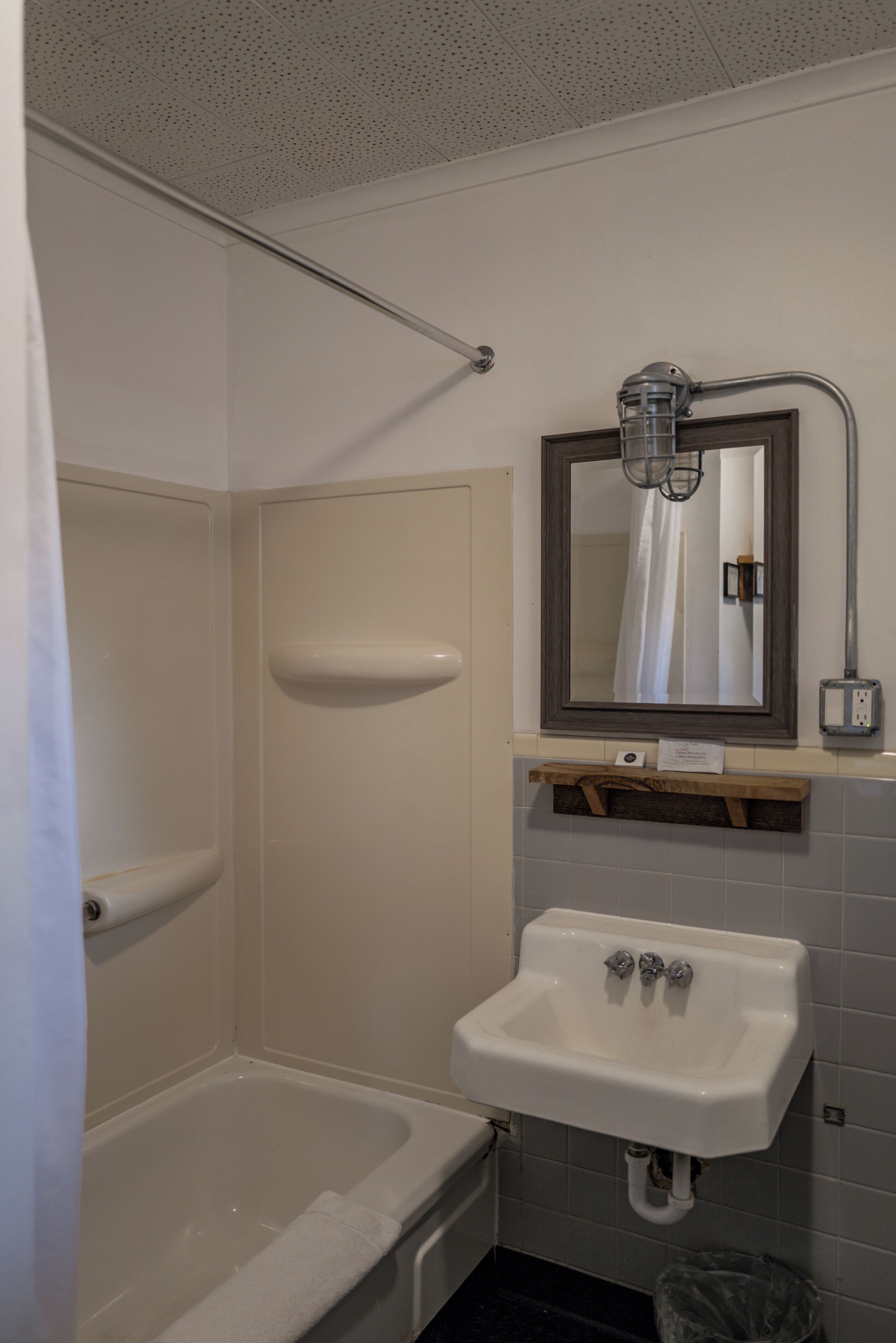 Un baño con bañera, lavabo, espejo y cortina de ducha.