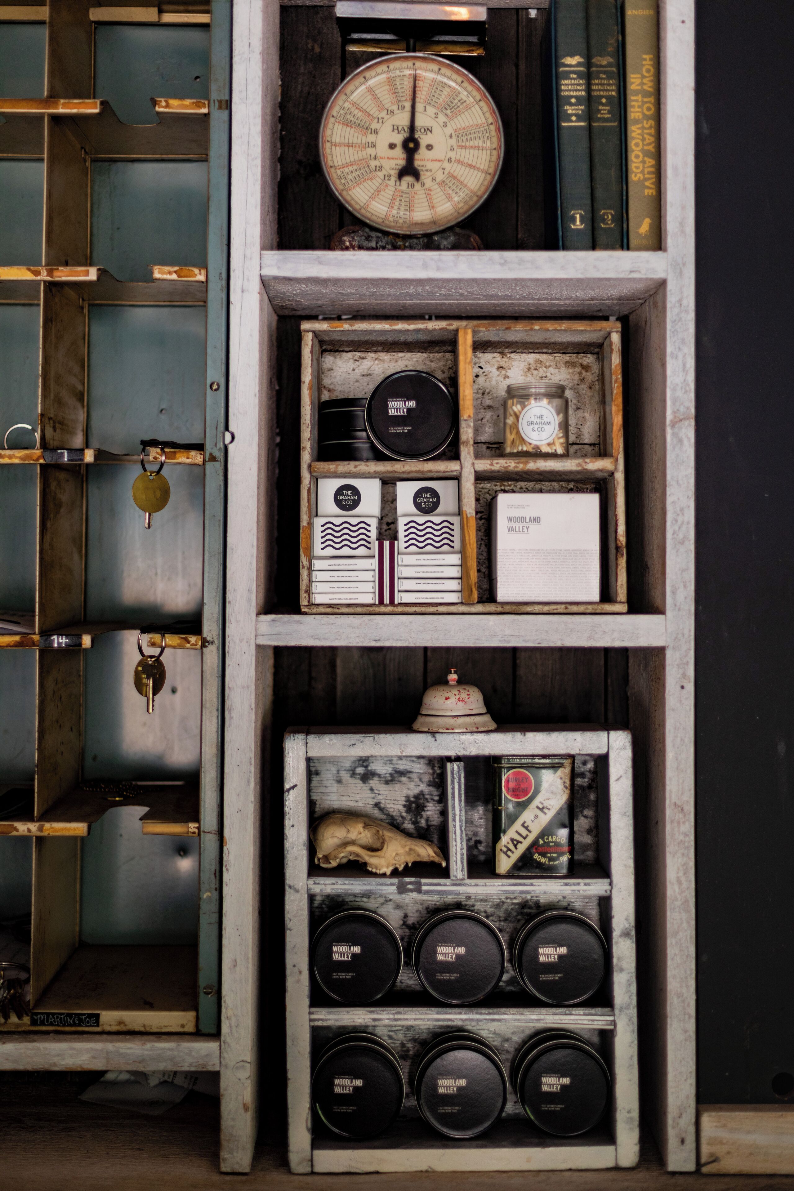 A vintage wooden shelf with various items including a clock, books, and containers.