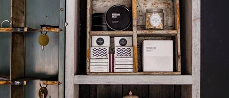 A vintage wooden shelf with various items including a clock, books, and containers.