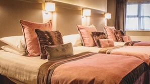 Een hotelkamer met twee bedden, elk met passende hoofdeinden en nachtkastjes.
