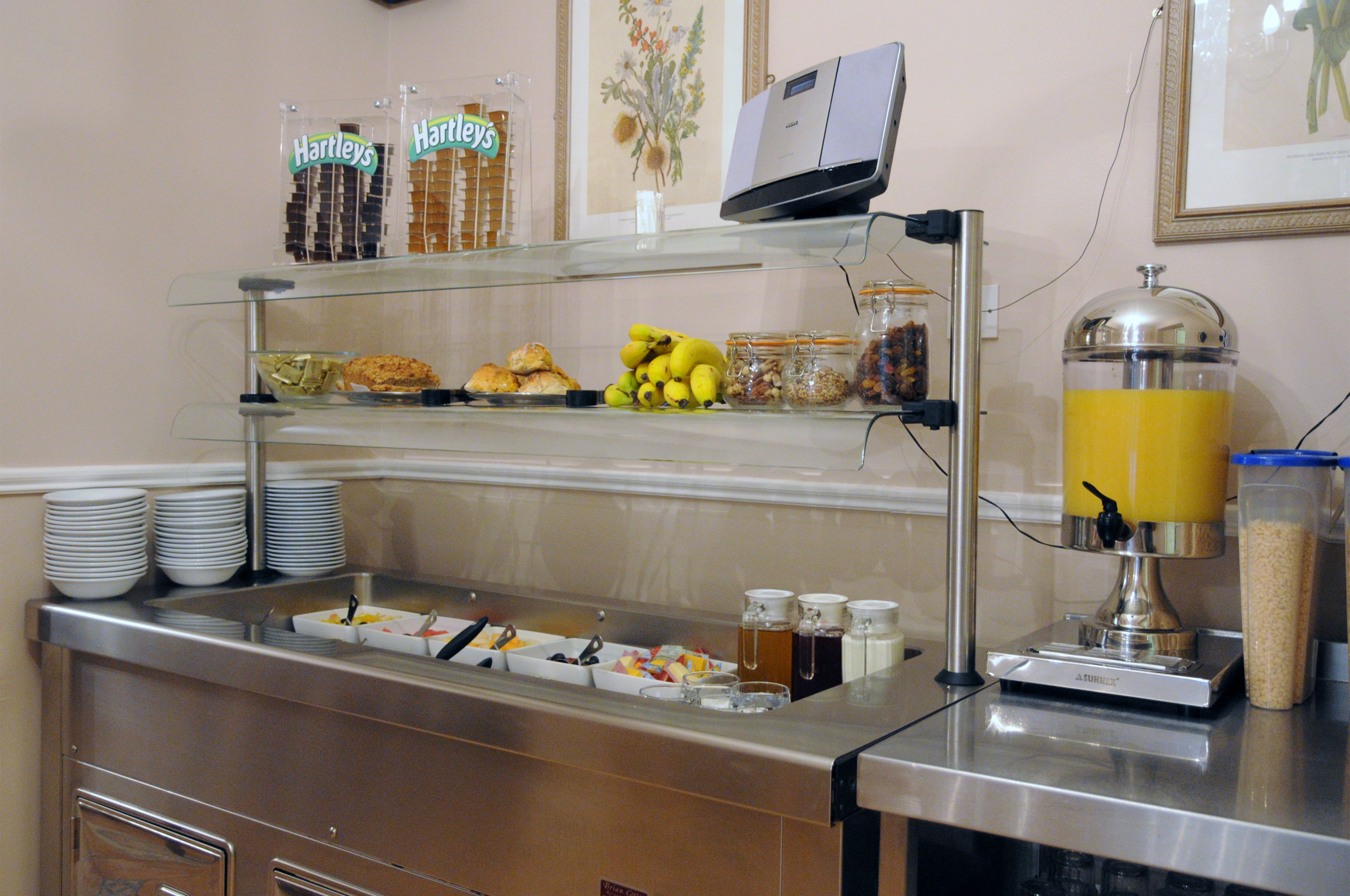 Een buffet met diverse gerechten en een sapautomaat.