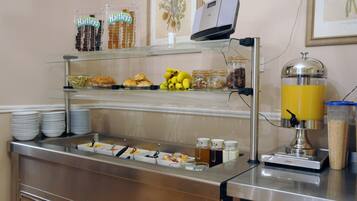 Een buffet met diverse gerechten en een sapautomaat.