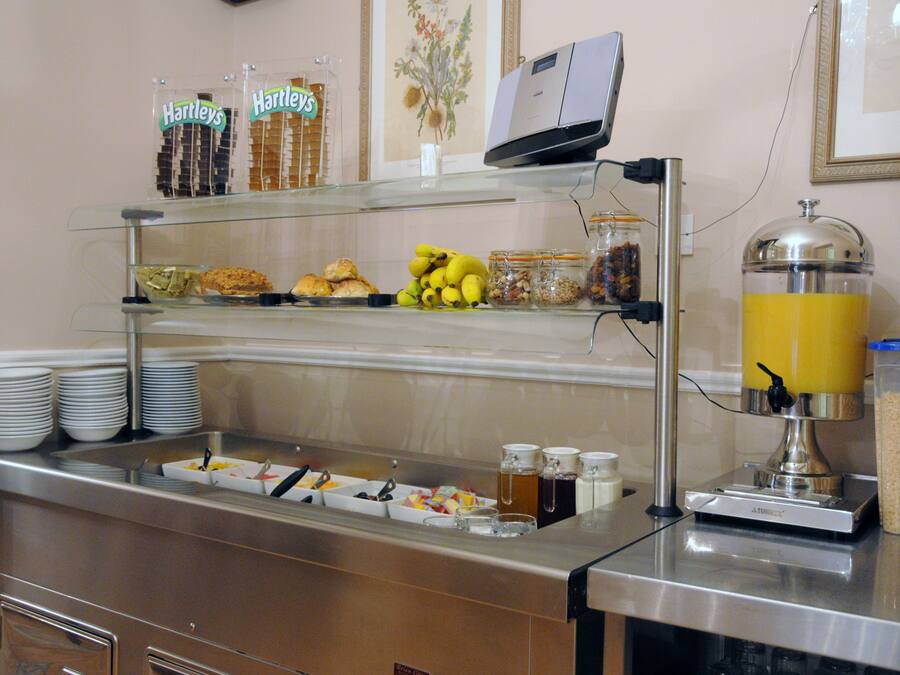 Een buffet met diverse gerechten en een sapautomaat.