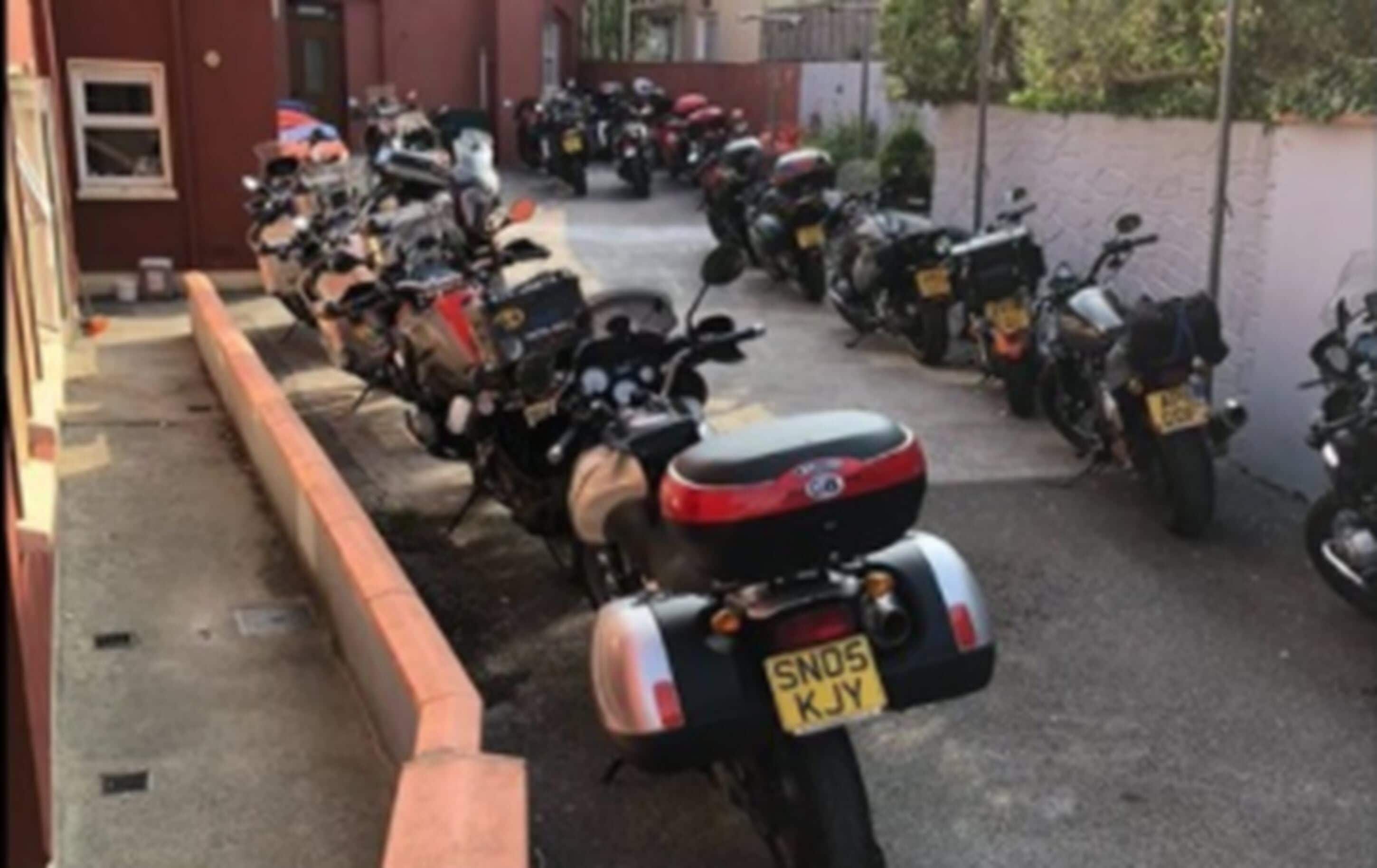 Une rang ée de motos garées dans une rue étroite.