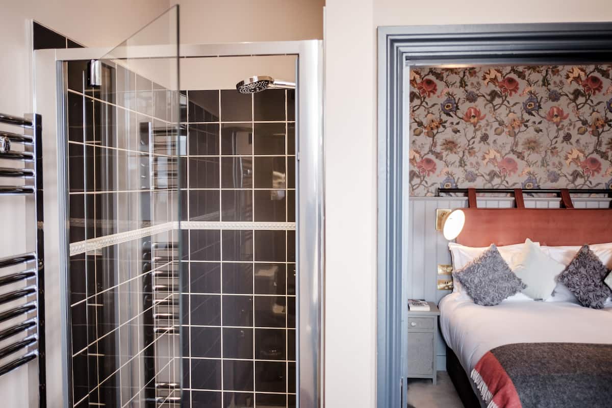 A modern bathroom with a glass shower enclosure and a separate toilet area.