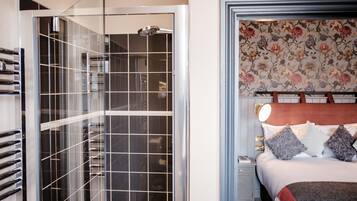 A modern bathroom with a glass-enclosed shower and a separate toilet area.