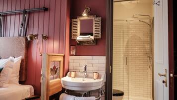 A bathroom with a white sink, a mirror, and a shower.