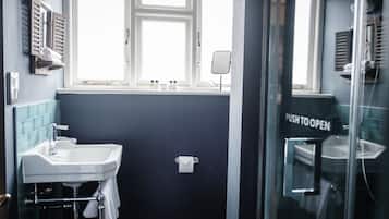 Un baño con lavamanos, espejo y ventana.