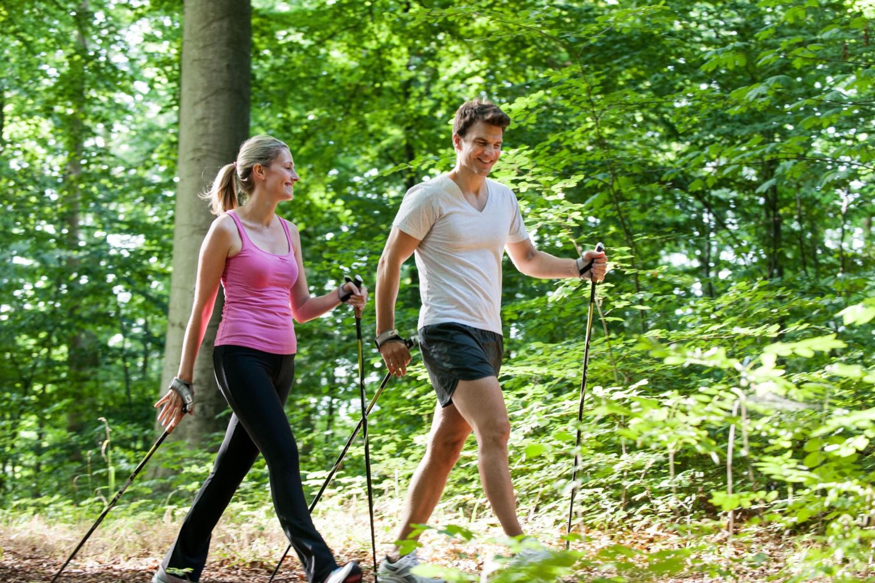 Two people hiking in a forested area.