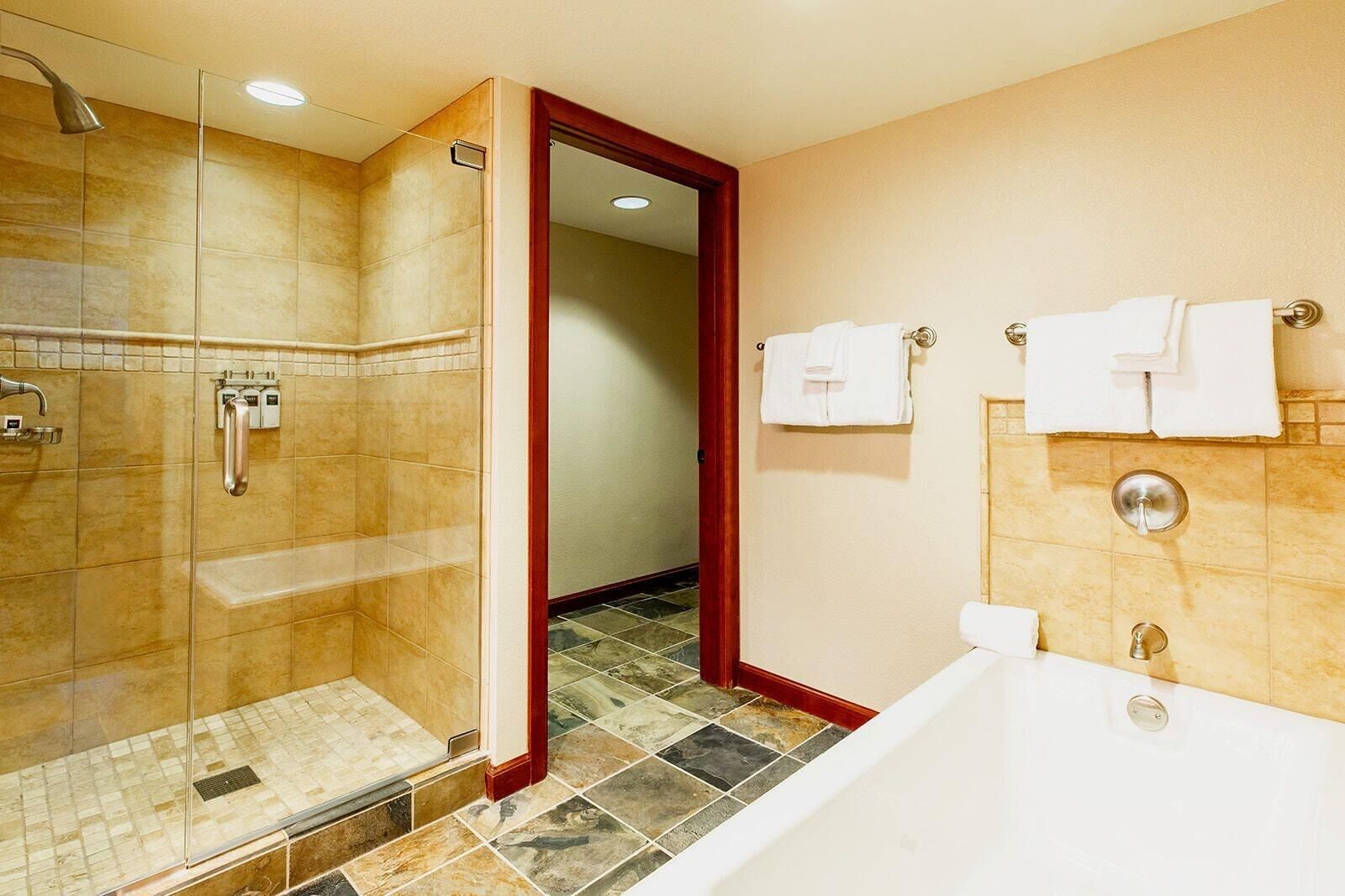 Une salle de bain avec une douche à parois de verre, une baignoire et des toilettes.