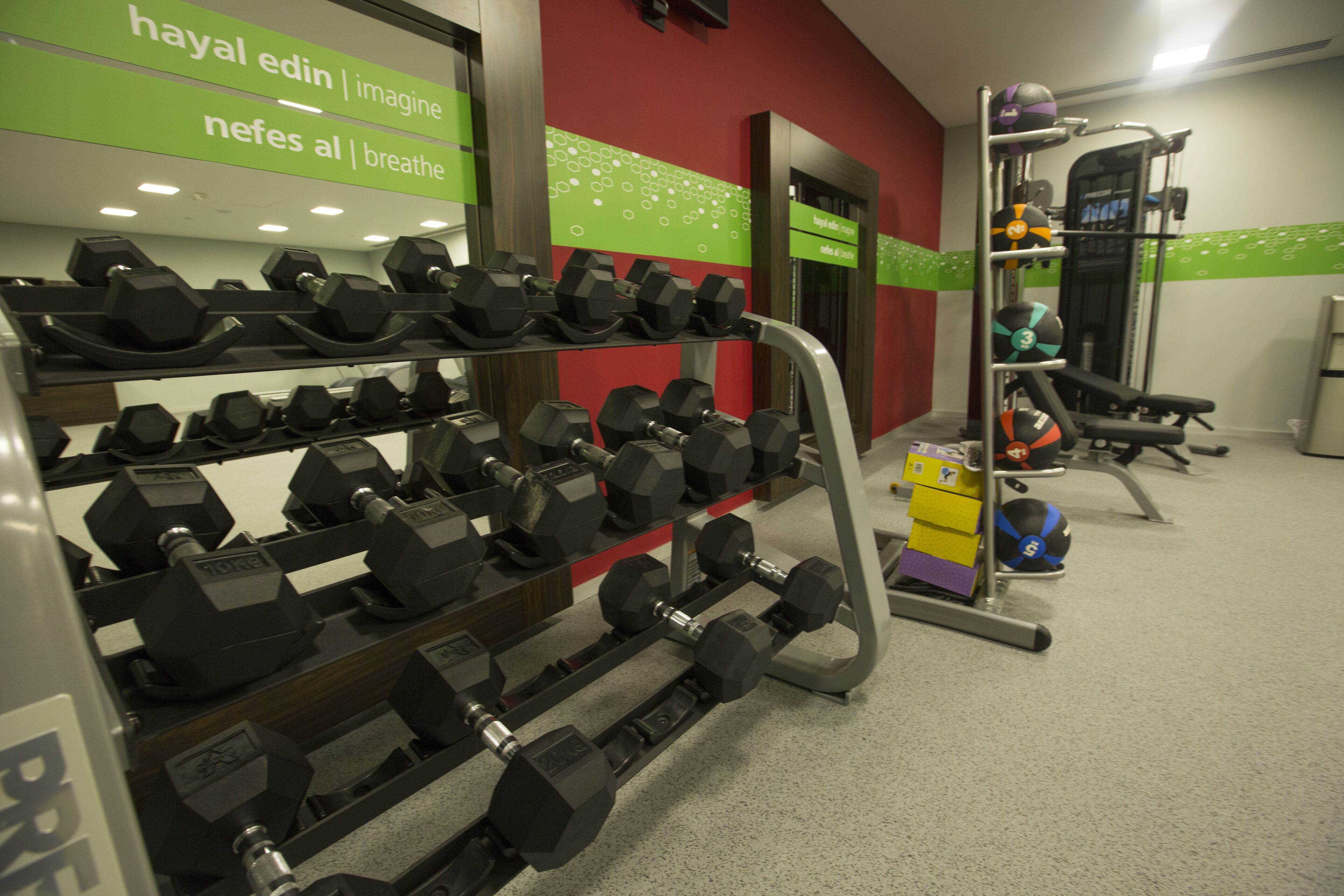 A gym with various exercise equipment, including dumbbells and a weight machine.