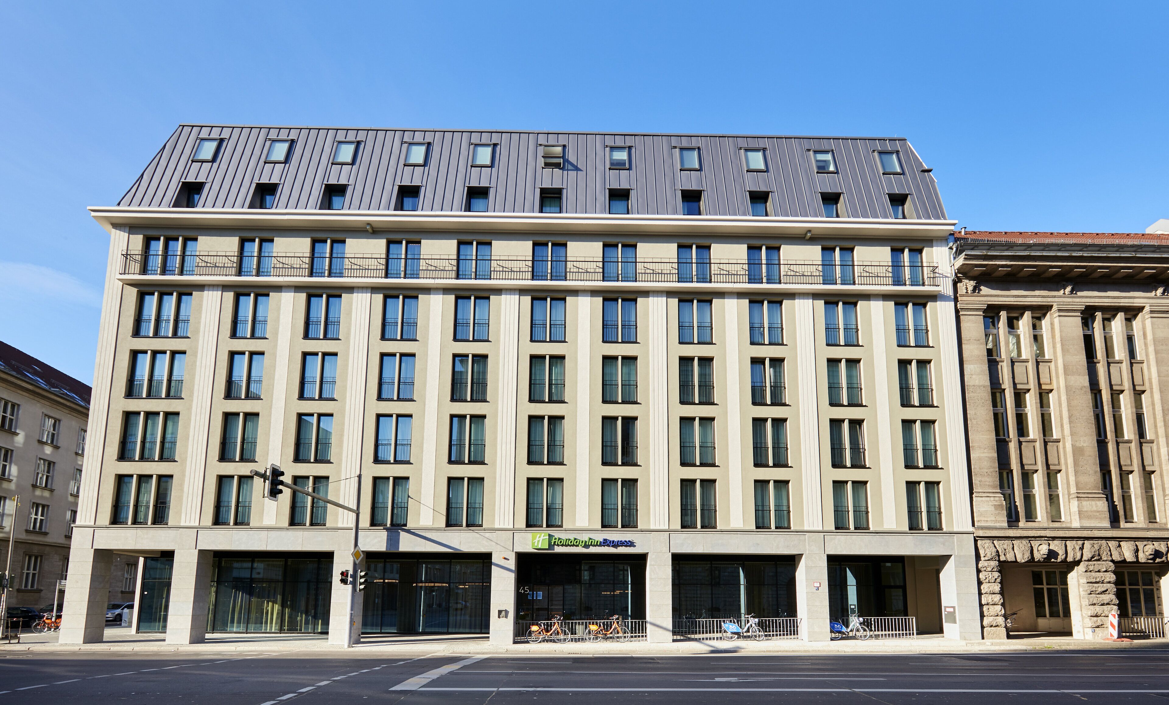 Un hotel moderno con techo plano, ventanas amplias y un letrero de Holiday Inn Express.