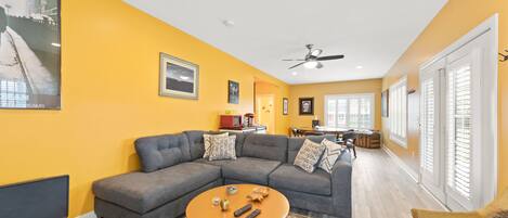 A living room with a sectional sofa, a coffee table, and a TV.