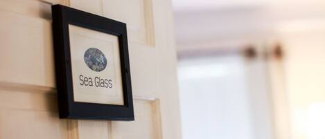 A framed picture with the text "Sea Glass" on a wall.
