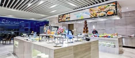 A modern buffet setup with a digital menu display, self-service stations, and a variety of food items.