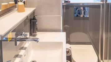 Une salle de bain avec un lavabo, des toilettes et un miroir.