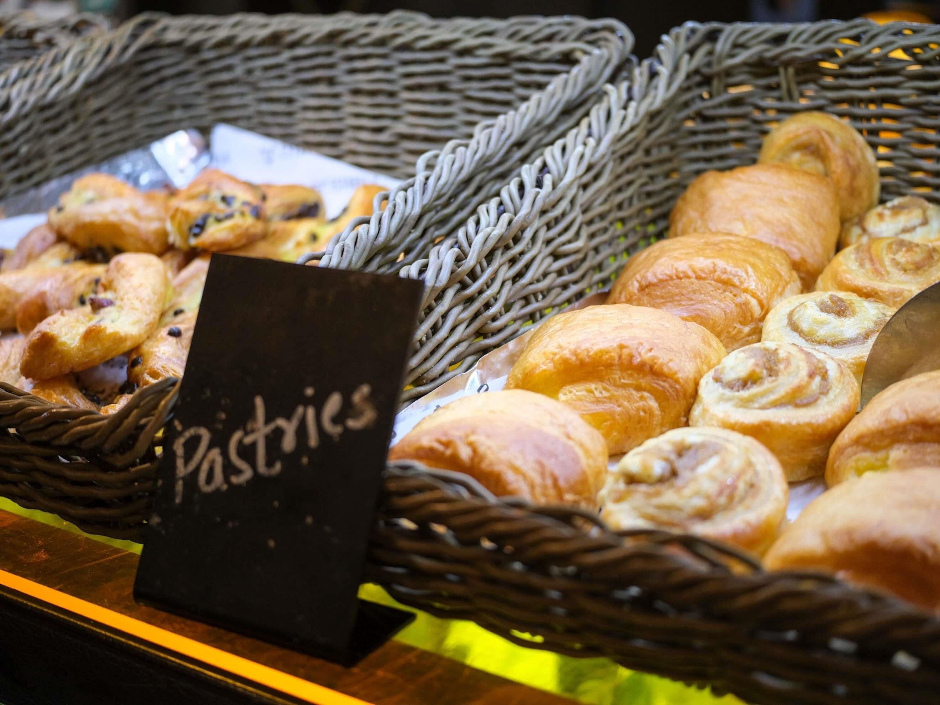A display of pastries in wicker baskets with a sign labeled 'Pastries'.