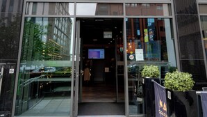 The exterior of the ibis Styles hotel at Leeds City Centre Arena, featuring a modern glass facade, a green logo, and a clear entrance.
