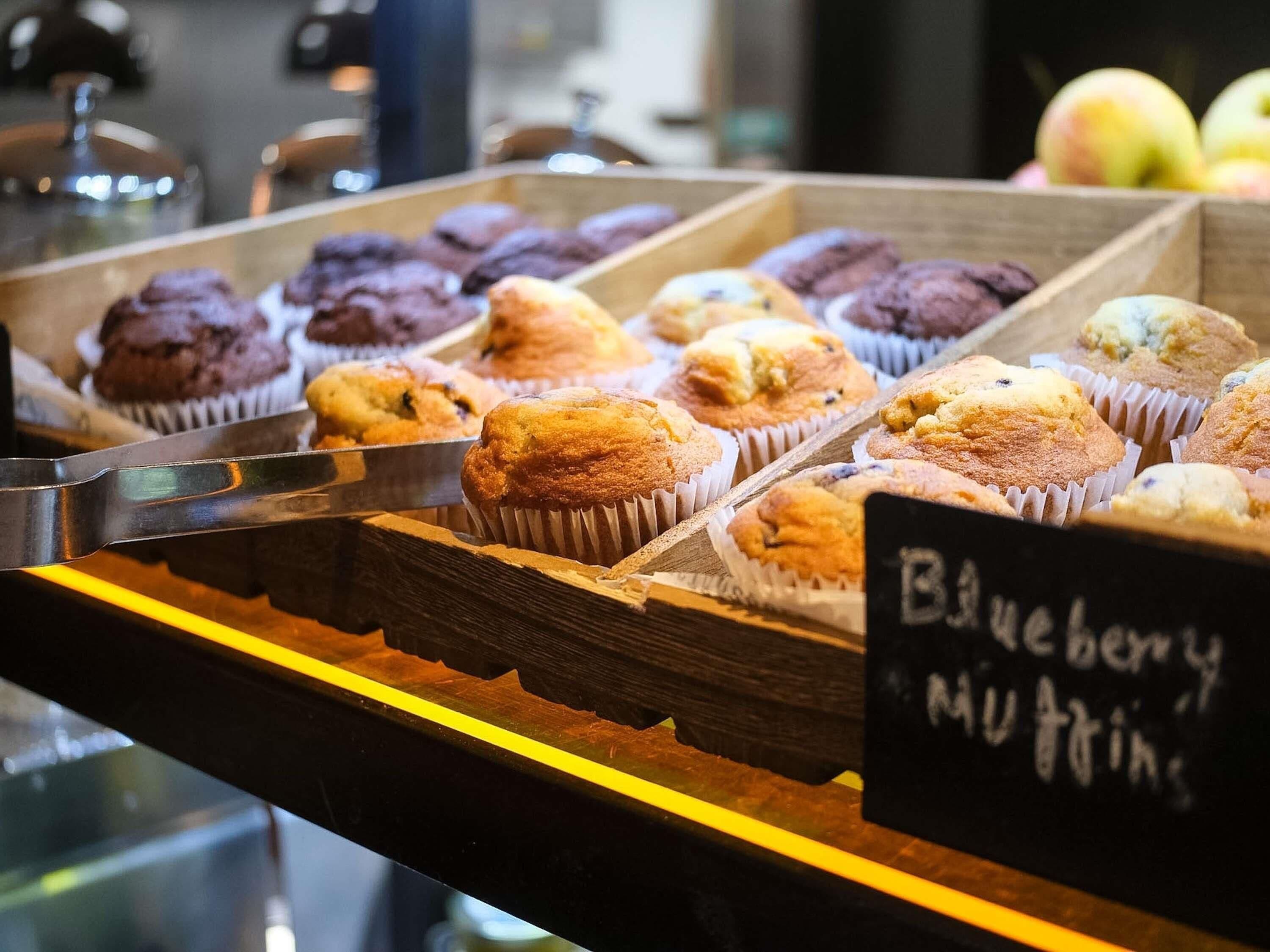 A display of muffins in a bakery setting.