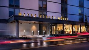 The exterior of the Hayes Street Hotel with illuminated signage and a well-lit entrance. - The Hayes Street Hotel, Trademark Collection by Wyndham (Nashville)