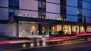 Exterior del Hotel Hayes con fachada moderna, amplias ventanas y una entrada bien iluminada.