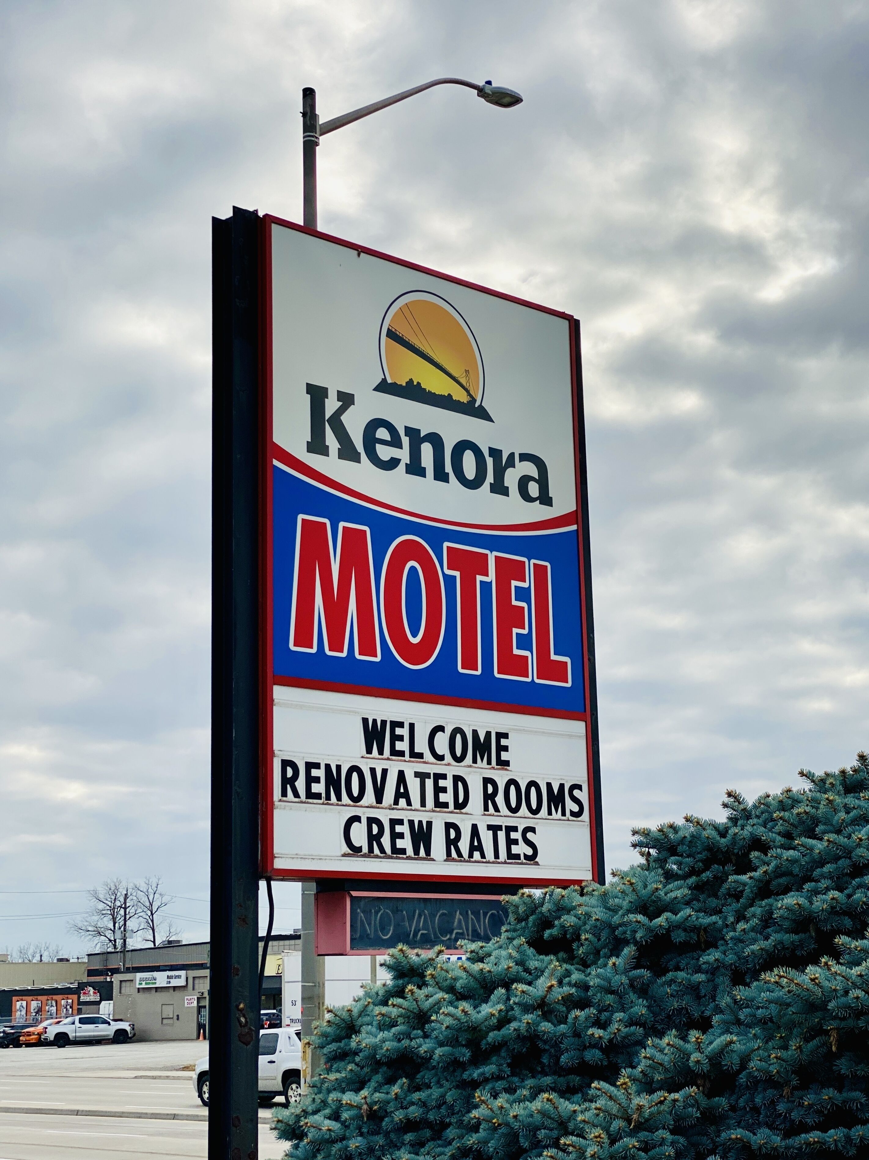 Señal de Kenora Motel con un mensaje de bienvenida, indicando habitaciones renovadas y tarifas para empleados.