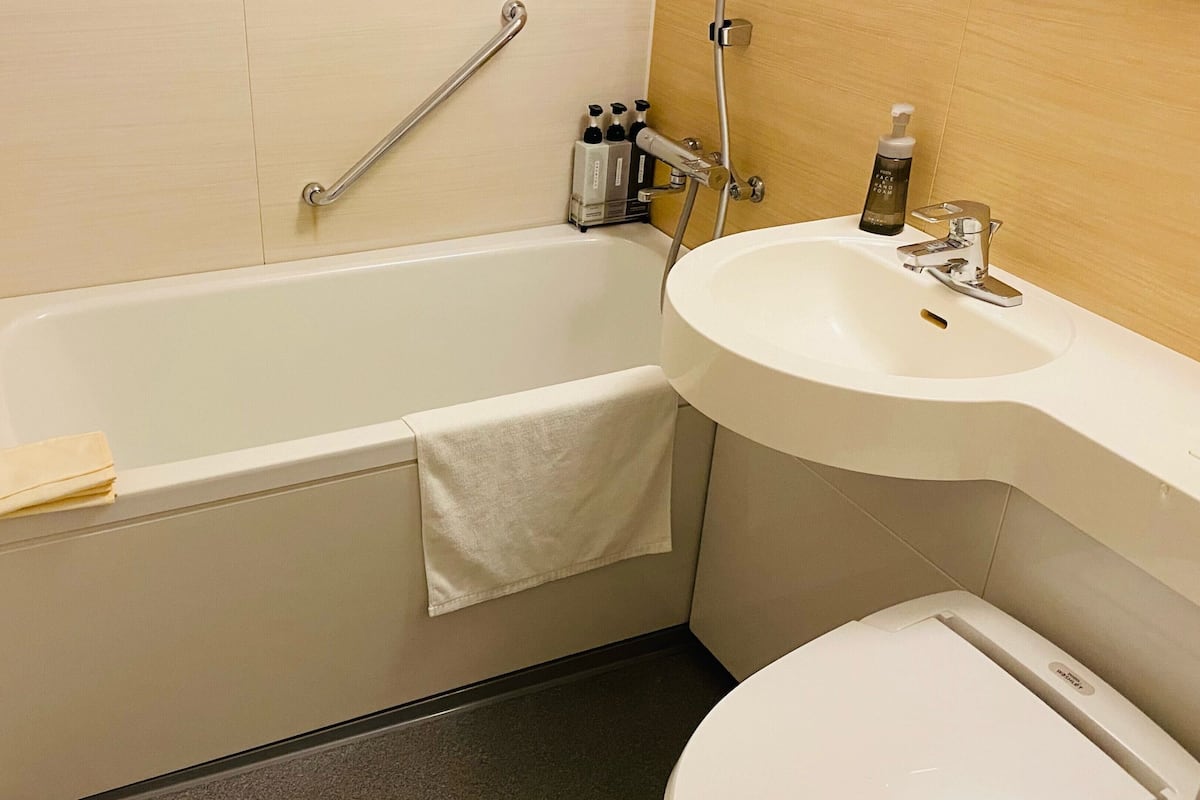 Een badkamer met een bad, wastafel en toilet.