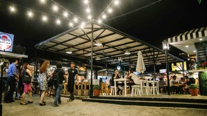 An outdoor dining area with a covered seating area, tables, and chairs. - Ortigas Budget Hotel - Kapitolyo (Pasig)