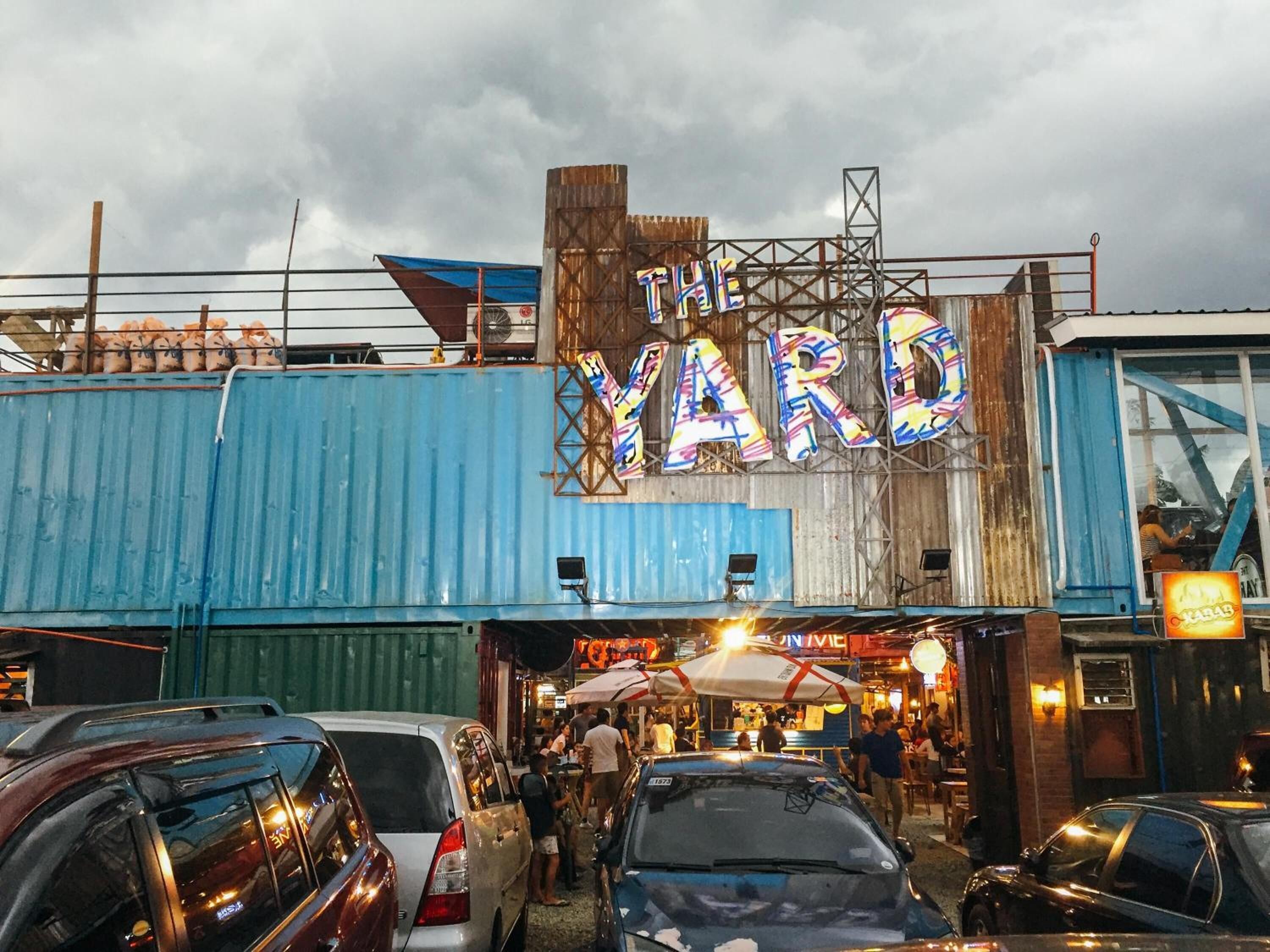Un edifici amb un rètol que diu “THE YARD” i una multitud de persones a l'exterior.