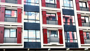 Un edificio de varios pisos con un diseño arquitectónico moderno, que cuenta con amplias ventanas y balcones.