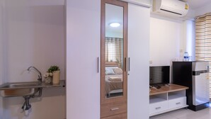 Une cuisine moderne dotée d’un évier encastré, d’un réfrigérateur et d’un meuble en bois avec des tiroirs.