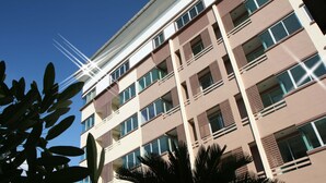 Un immeuble à plusieurs étages doté d’une architecture moderne, avec des balcons et de grandes fenêtres.