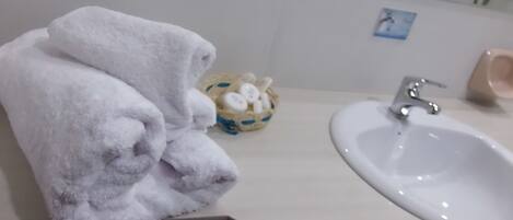 A bathroom with a sink, a mirror, and a towel rack.