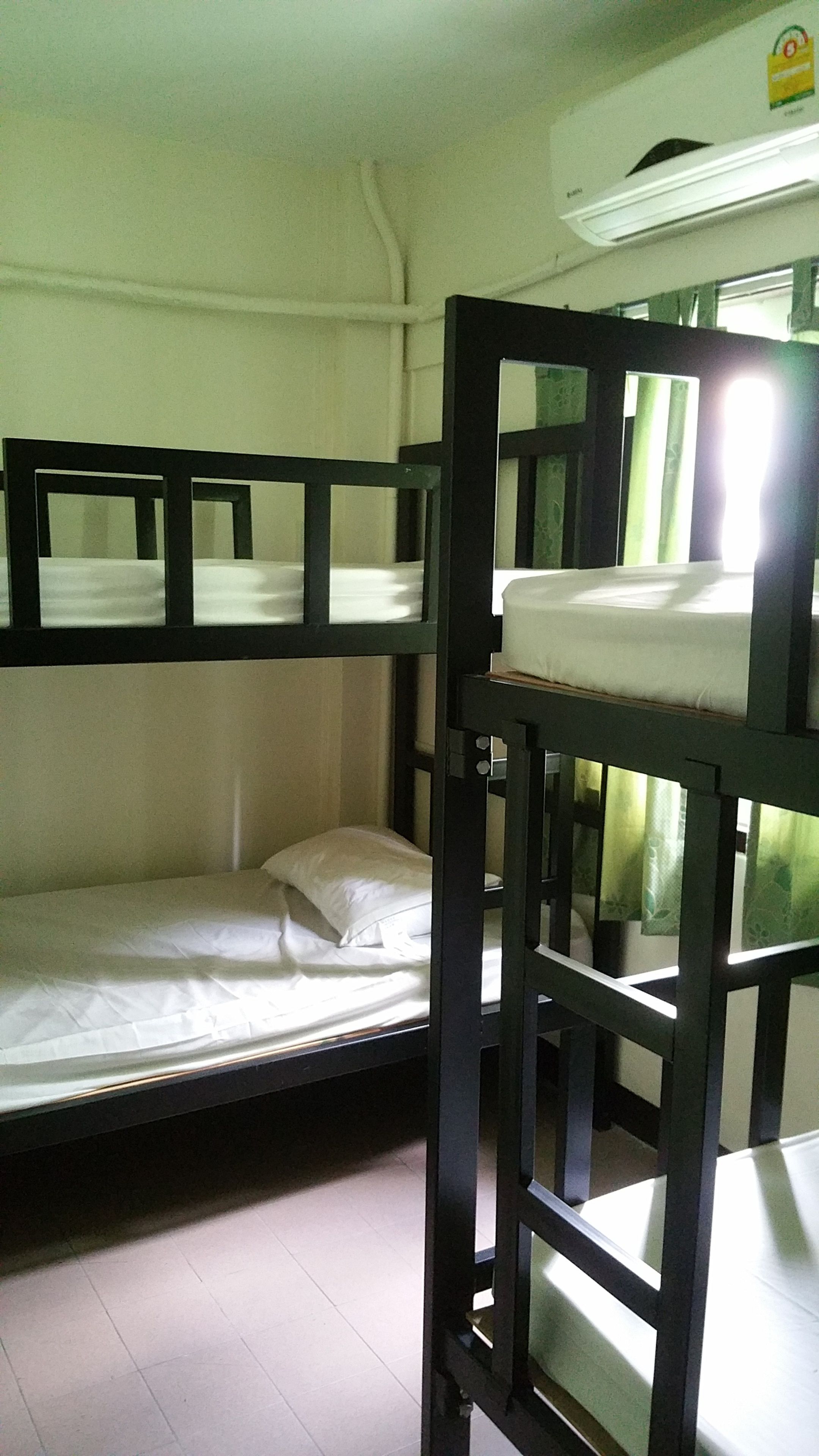 Een slaapkamer met een tweepersoonsbed en een witte plafond, plus een zichtbare airconditioning.