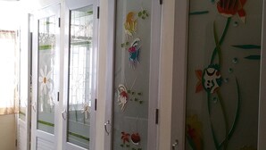 A row of doors with decorative glass panels featuring floral and aquatic designs. - Relax Time Silom - Hostel (Bangkok)
