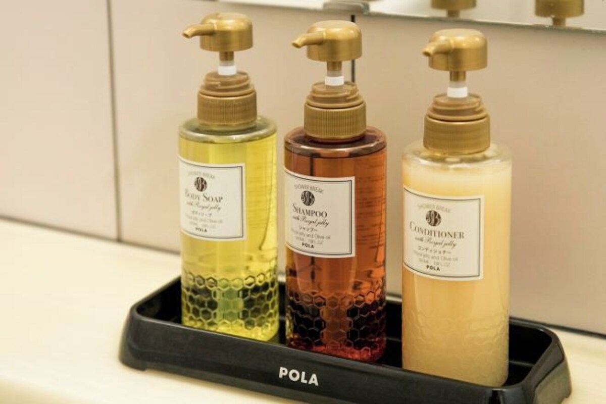 Trois bouteilles de savon sur un plateau portant l’étiquette « POLA ».