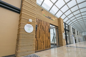 A Grand MASTARS cafe with a modern wooden facade and a glass ceiling.
