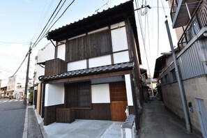 Ein traditionelles japanisches Gebäude mit Holzfassade, einem Ziegeldach und einem kleinen Balkon.